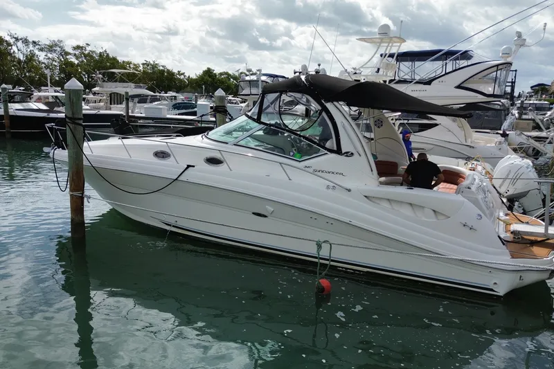Slide: The Image of 2004 Sea Ray 340 Sundancer yacht docked in a marina, surrounded by other boats. - 15