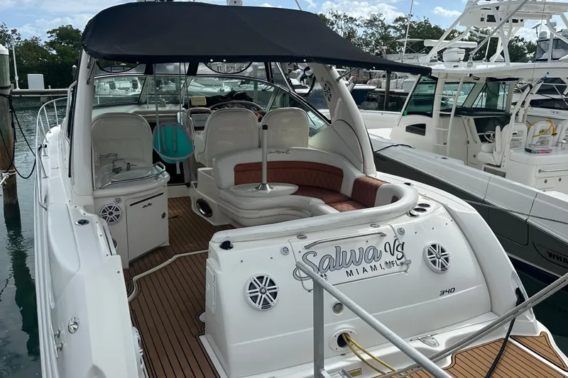 Slide: The Image of 2004 Sea Ray 340 Sundancer yacht docked, featuring spacious seating and sleek design. - 18