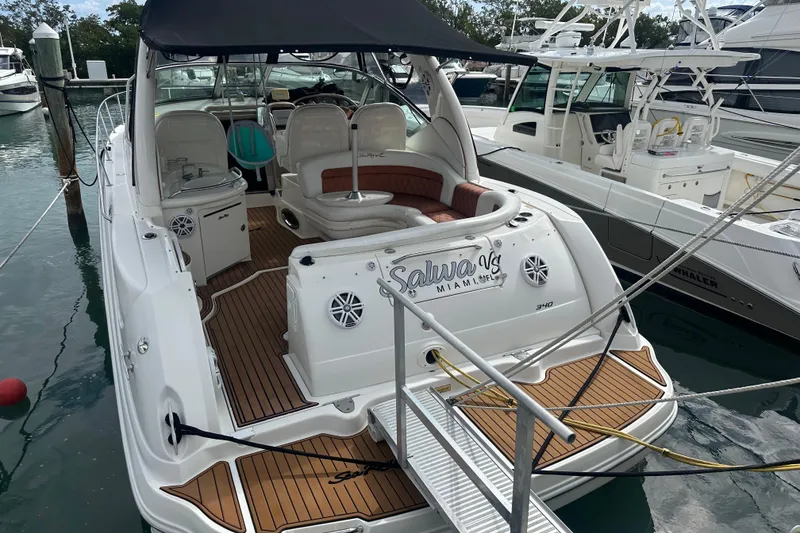 Slide: The Image of 2004 Sea Ray 340 Sundancer yacht docked, featuring spacious deck and elegant seating. - 19