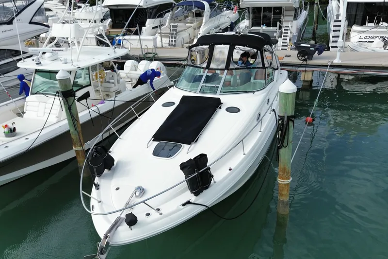 Slide: The Image of 2004 Sea Ray 340 Sundancer docked at marina, surrounded by other boats. - 2