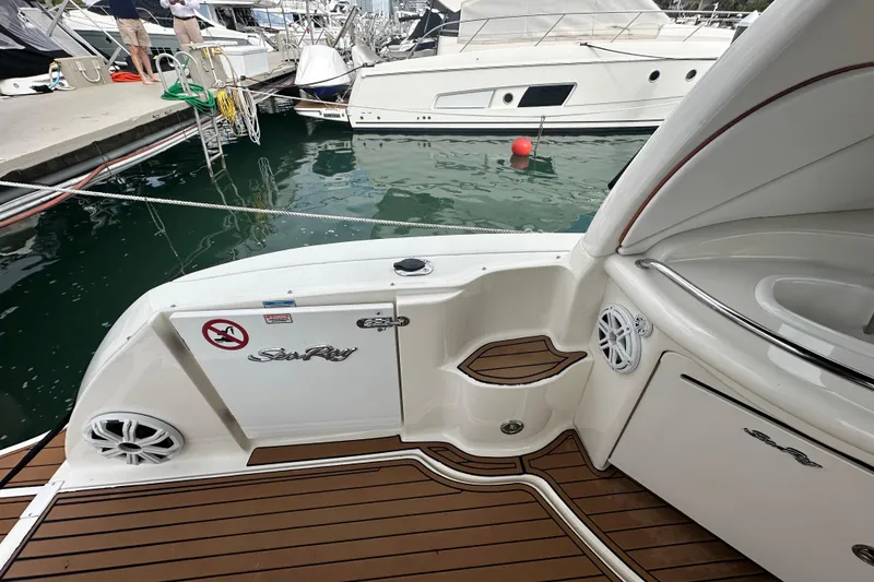 Slide: The Image of 2004 Sea Ray 340 Sundancer boat docked, featuring sleek deck design and branded logo. - 22