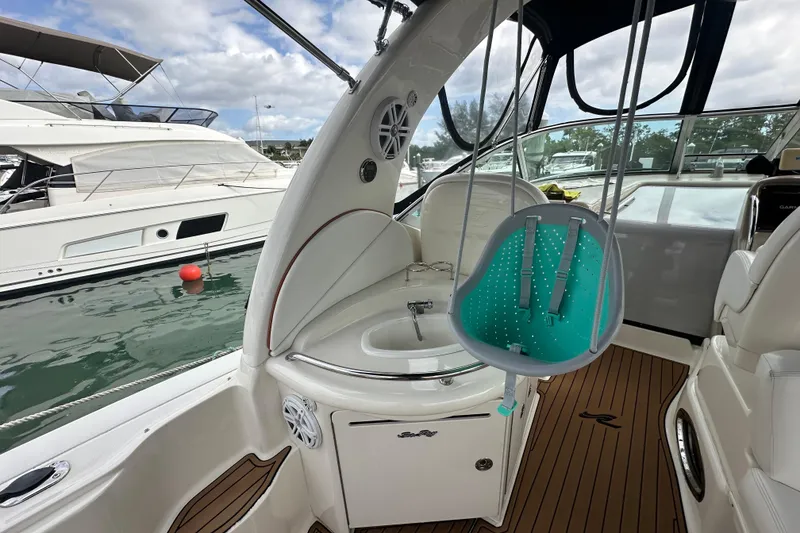 Slide: The Image of 2004 Sea Ray 340 Sundancer interior with a child's swing, docked at marina. - 23