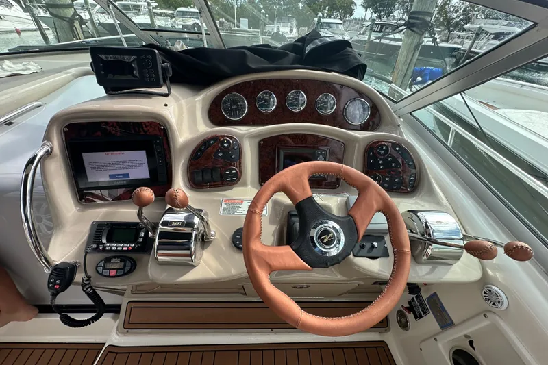 Slide: The Image of 2004 Sea Ray 340 Sundancer helm with leather steering wheel and navigation controls. - 26