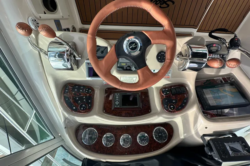 Slide: The Image of 2004 Sea Ray 340 Sundancer helm with leather steering wheel and navigation controls. - 27