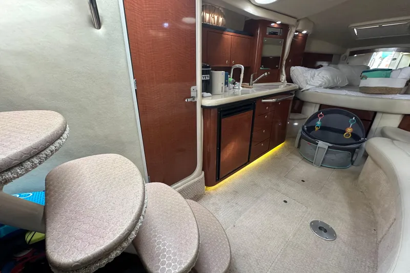 Slide: The Image of Interior of 2004 Sea Ray 340 Sundancer yacht with kitchenette and cozy seating area. - 36
