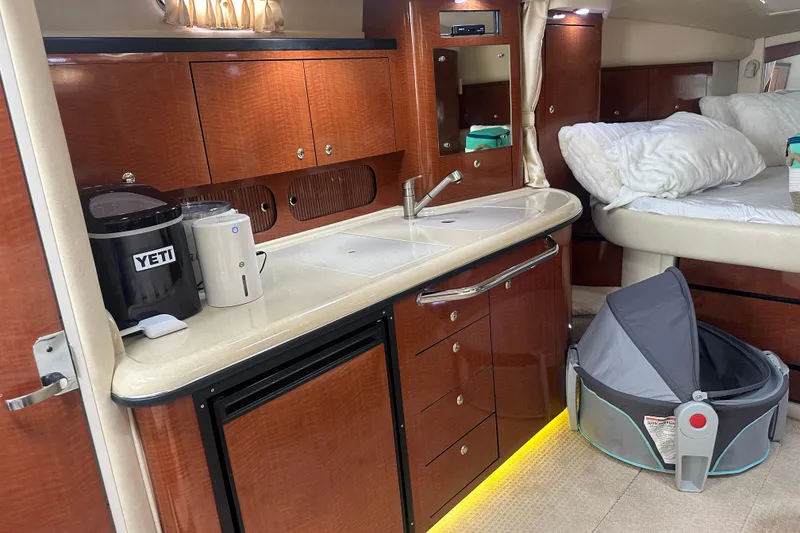 Slide: The Image of 2004 Sea Ray 340 Sundancer cabin interior with kitchenette and sleeping area. - 44