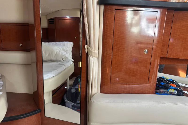 Slide: The Image of Interior of 2004 Sea Ray 340 Sundancer with wood cabinetry and cozy sleeping area. - 47