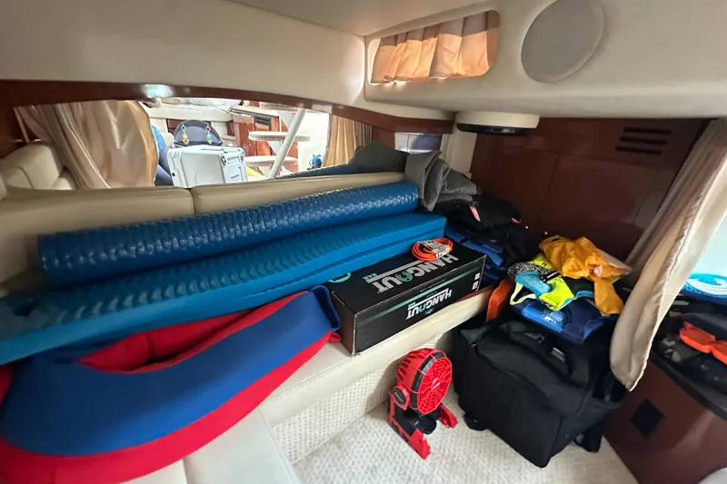 Slide: The Image of Interior of a 2004 Sea Ray 340 Sundancer with various stored items and equipment. - 50