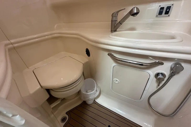 Slide: The Image of 2004 Sea Ray 340 Sundancer bathroom with toilet, sink, and wooden floor. - 52