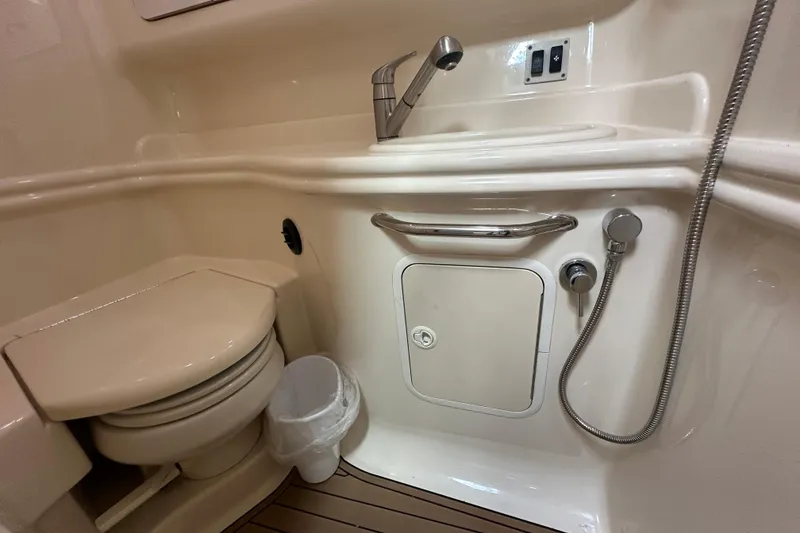 Slide: The Image of 2004 Sea Ray 340 Sundancer bathroom with toilet, sink, and showerhead. - 54