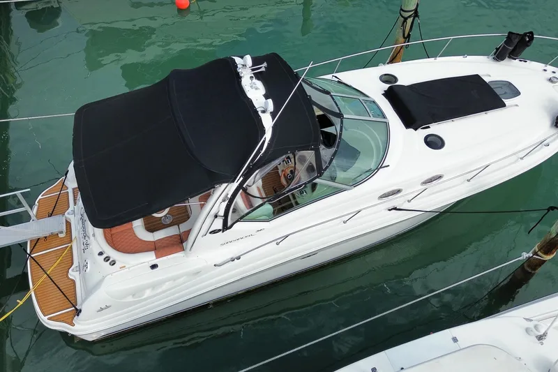 Slide: The Image of 2004 Sea Ray 340 Sundancer yacht docked, featuring sleek design and black canopy. - 6