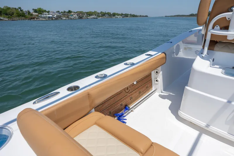 Slide: The Image of 2024 NauticStar 252 Legacy boat interior with tan seating and ocean view. - 16