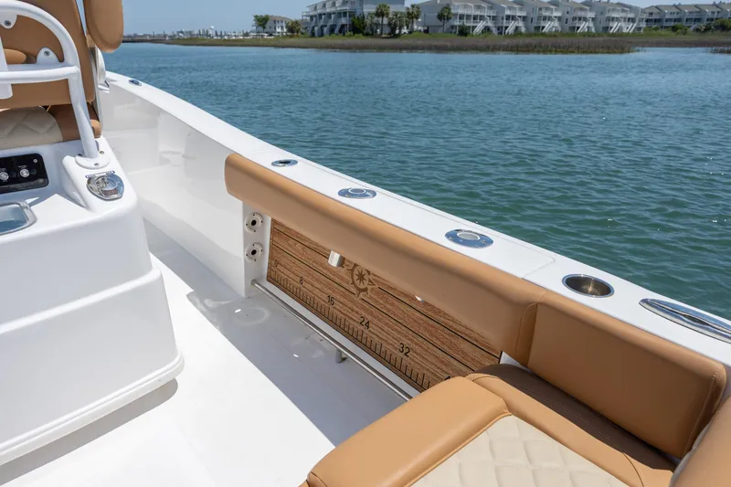 Slide: The Image of 2024 NauticStar 252 Legacy boat interior with tan seating and built-in measuring ruler. - 17