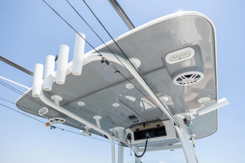 Slide: The Image of 2024 NauticStar 252 Legacy boat roof with rod holders and speakers under clear sky. - 21