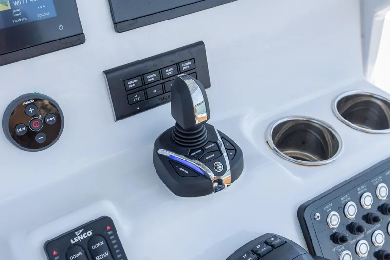 Slide: The Image of 2024 NauticStar 252 Legacy boat console with joystick controls and cup holders. - 23