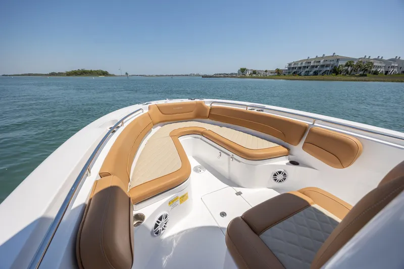 Slide: The Image of 2024 NauticStar 252 Legacy boat interior with tan seating on calm water. - 28