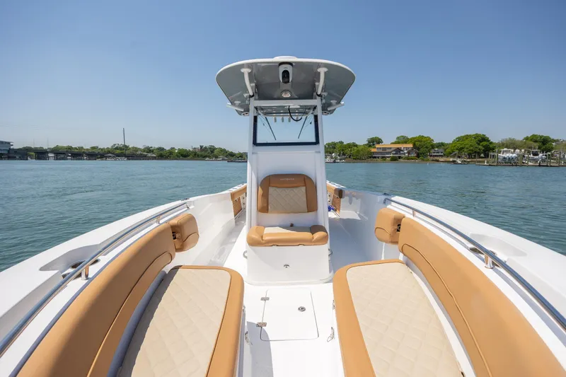 Slide: The Image of 2024 NauticStar 252 Legacy boat with tan seating on calm water. - 30