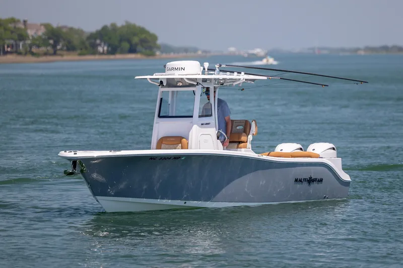 Slide: The Image of 2024 NauticStar 252 Legacy boat cruising on a calm, scenic waterway. - 4