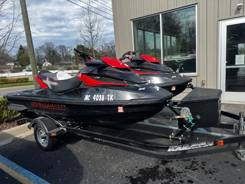 Slide: The Image of Two 2011 Sea-Doo RXT 260 jet skis on trailer outside building. - 2