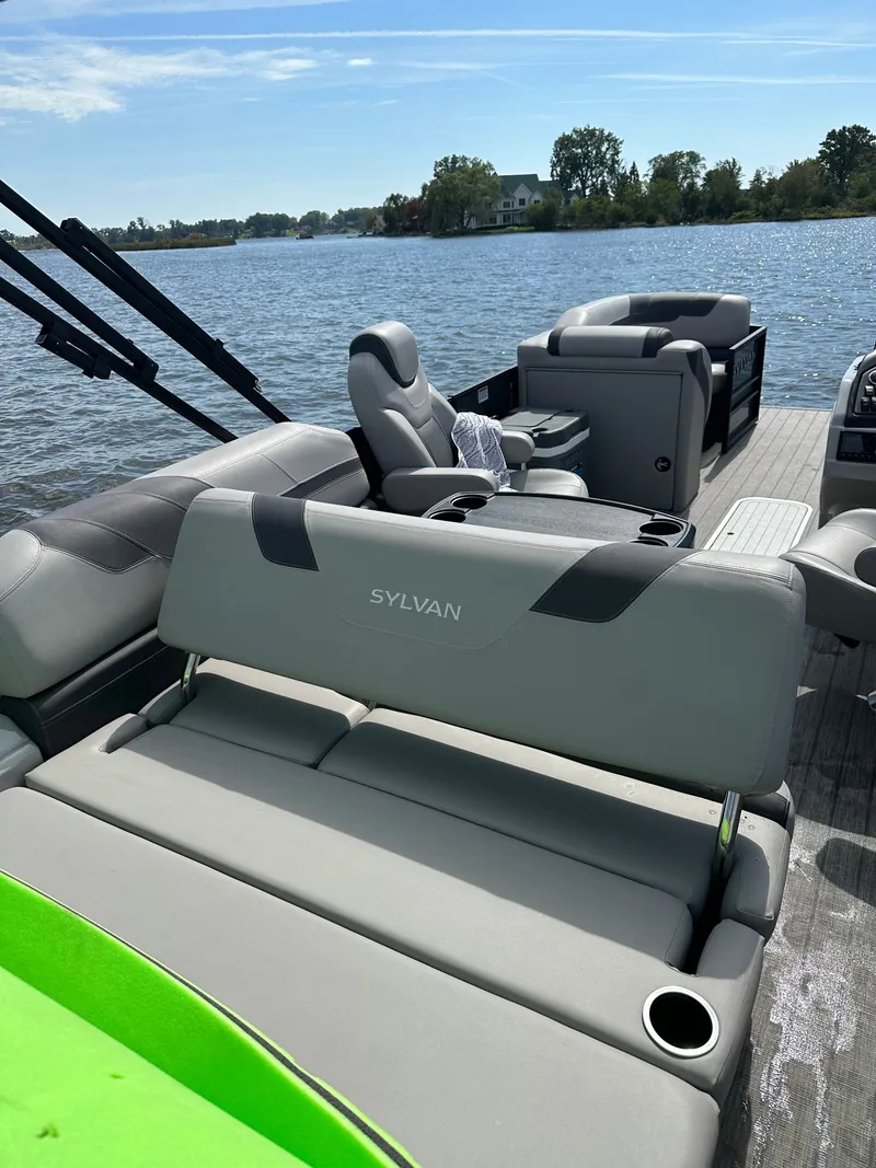 Slide: The Image of 2022 Sylvan L3 CLZ TT pontoon boat on a serene lake. - 8
