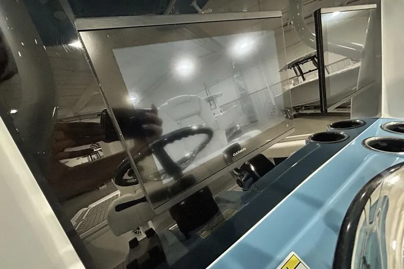 Slide: The Image of 2026 Tidewater 2500 Carolina Bay boat dashboard with Garmin display and cup holders. - 11