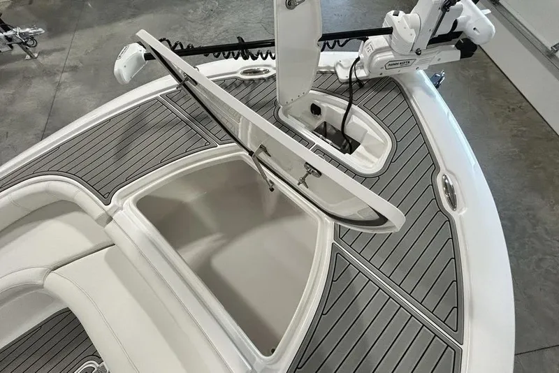 Slide: The Image of 2026 Tidewater 2500 Carolina Bay boat deck with open storage compartment and trolling motor. - 12