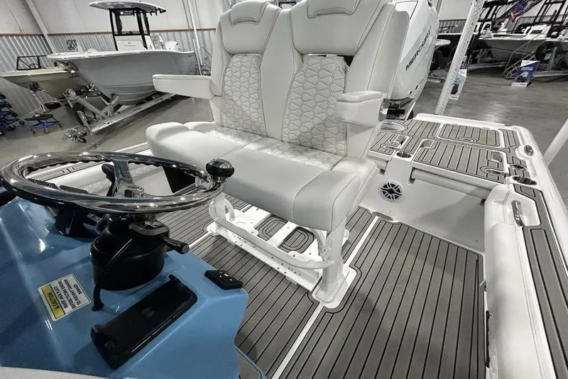 Slide: The Image of 2026 Tidewater 2500 Carolina Bay boat interior with steering wheel and cushioned seating. - 8