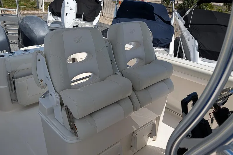 Slide: The Image of 2014 Sailfish 270 CC boat interior with dual white cushioned seats. - 13