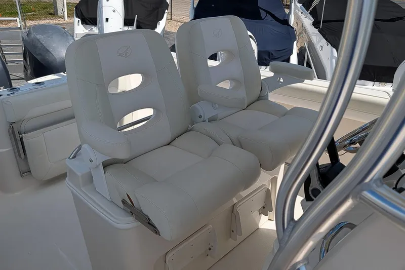 Slide: The Image of 2014 Sailfish 270 CC boat with dual white cushioned seats and armrests. - 14