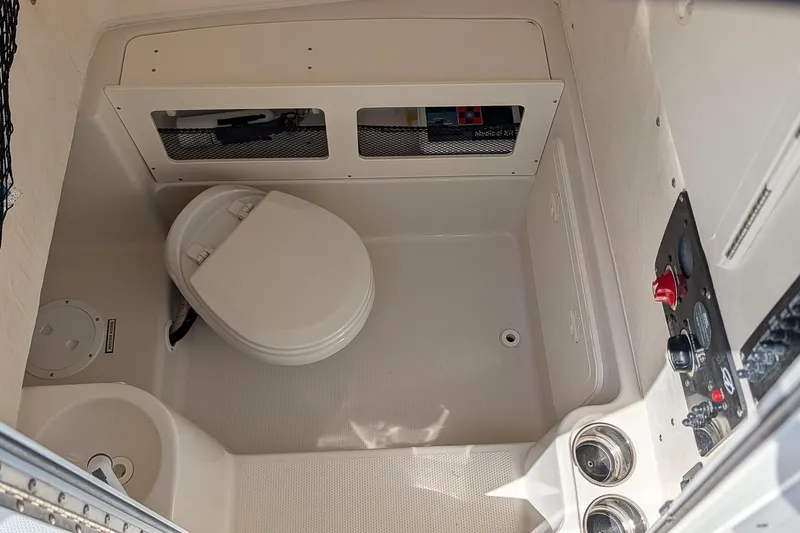 Slide: The Image of Interior of a 2014 Sailfish 270 CC boat featuring a compact marine toilet. - 19
