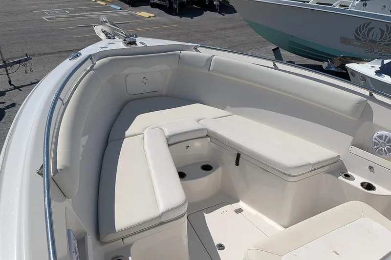 Slide: The Image of 2014 Sailfish 270 CC boat interior with white cushioned seating and cup holders. - 21