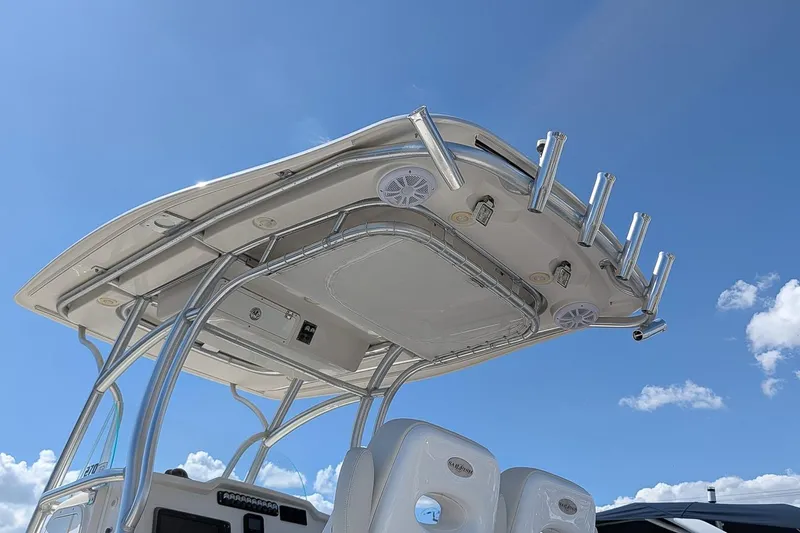 Slide: The Image of 2014 Sailfish 270 CC boat's T-top with rod holders against blue sky. - 23