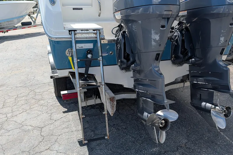 Slide: The Image of 2014 Sailfish 270 CC boat with dual outboard motors and a boarding ladder. - 6