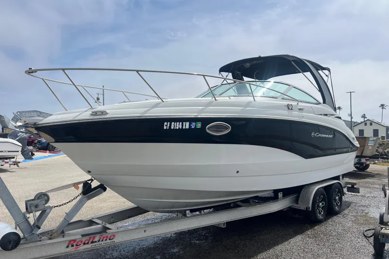 The Image of 2021 Crownline 264 CR boat on trailer, parked outdoors under a clear sky. - 0