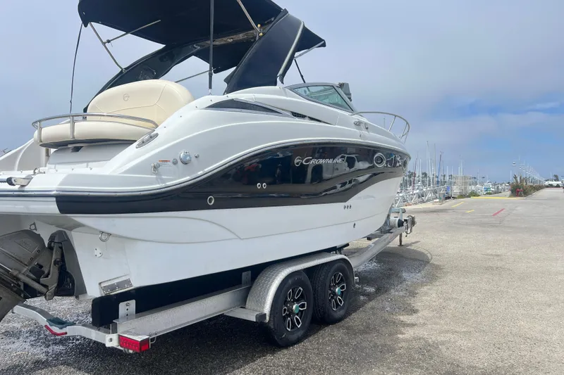 Slide: The Image of 2021 Crownline 264 CR boat on trailer at marina, overcast sky. - 13