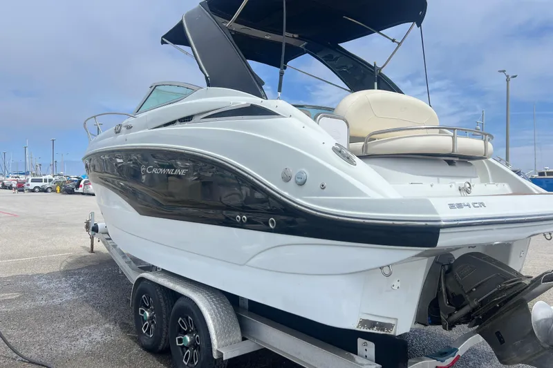 Slide: The Image of 2021 Crownline 264 CR boat on trailer at marina, showcasing sleek design and modern features. - 14
