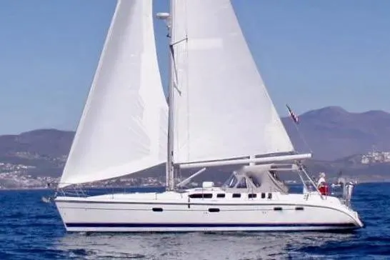 The Image of Sailing yacht Hunter 460, 2000 model, cruising on open water with mountains in the background. - 0