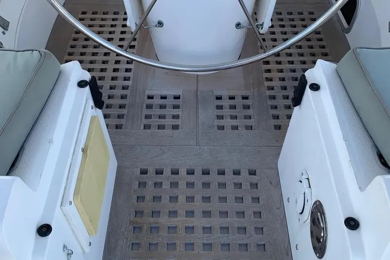 Slide: The Image of Interior of a 2000 Hunter 460 sailboat with wooden flooring and steering wheel. - 12