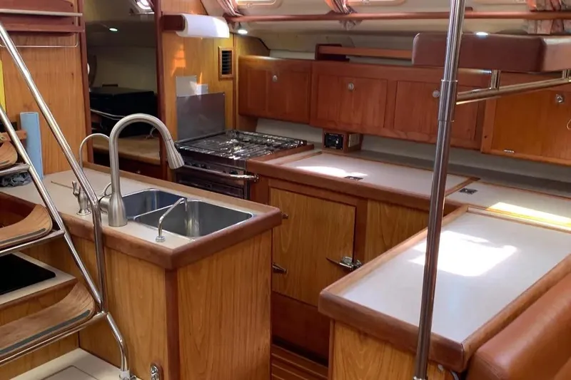 Slide: The Image of Interior of a 2000 Hunter 460 yacht kitchen with wooden cabinetry and stainless steel sink. - 27