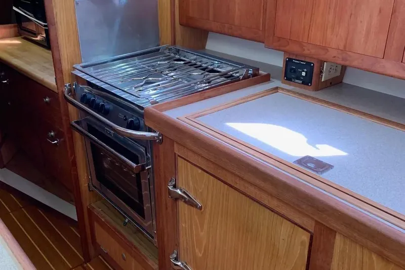 Slide: The Image of Wooden interior of a 2000 Hunter 460 yacht kitchen with stove and counter. - 28