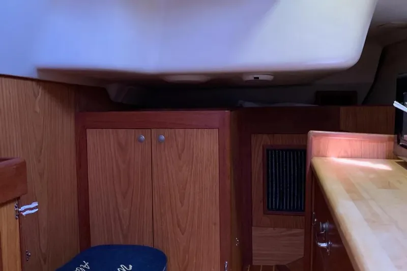 Slide: The Image of Interior of a 2000 Hunter 460 sailboat featuring wooden cabinetry and a compact layout. - 31
