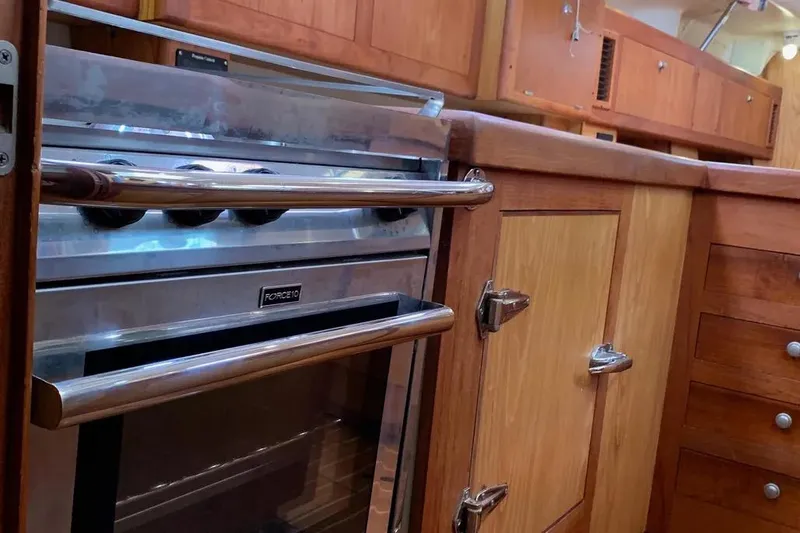 Slide: The Image of Interior of a 2000 Hunter 460 yacht kitchen with wooden cabinetry and a Force 10 stove. - 33