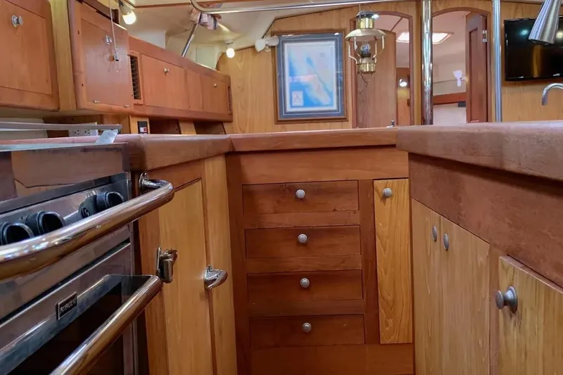 Slide: The Image of Wooden interior of a 2000 Hunter 460 yacht kitchen with stove and cabinets. - 34
