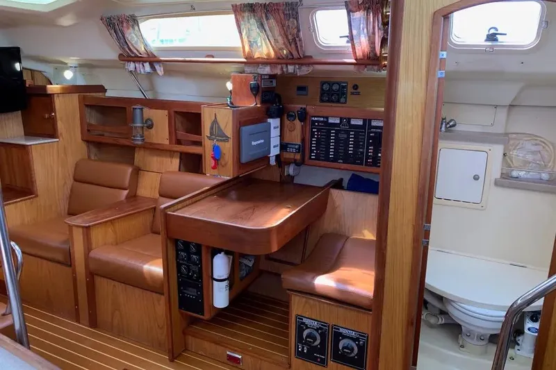 Slide: The Image of Interior of a 2000 Hunter 460 sailboat featuring wood finishes and a compact bathroom. - 39