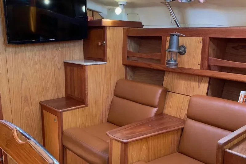 Slide: The Image of Interior of a 2000 Hunter 460 yacht with wood paneling and leather seating. - 44