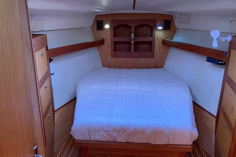 Slide: The Image of Cozy cabin interior of a 2000 Hunter 460 sailboat with wood paneling and a comfortable bed. - 45