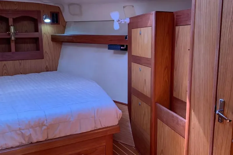 Slide: The Image of Cozy cabin interior of 2000 Hunter 460 yacht with wooden furnishings and bed. - 46
