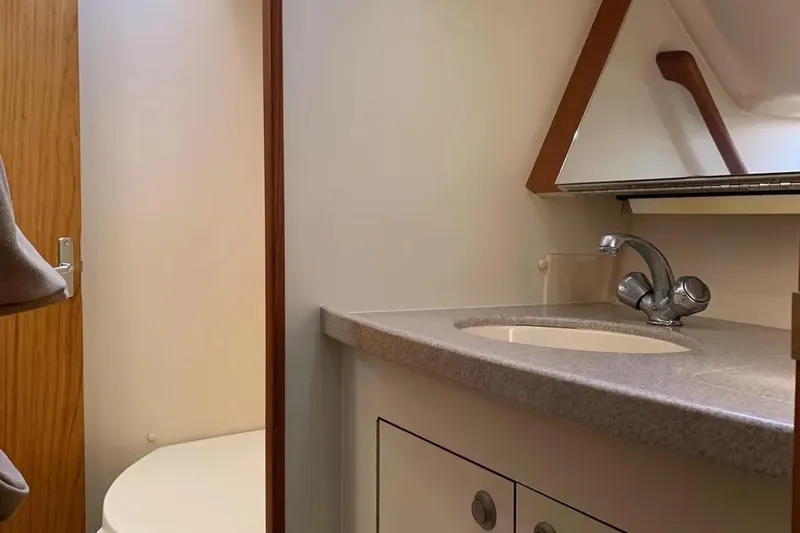 Slide: The Image of Interior of 2000 Hunter 460 yacht bathroom with sink, mirror, and wooden door. - 58