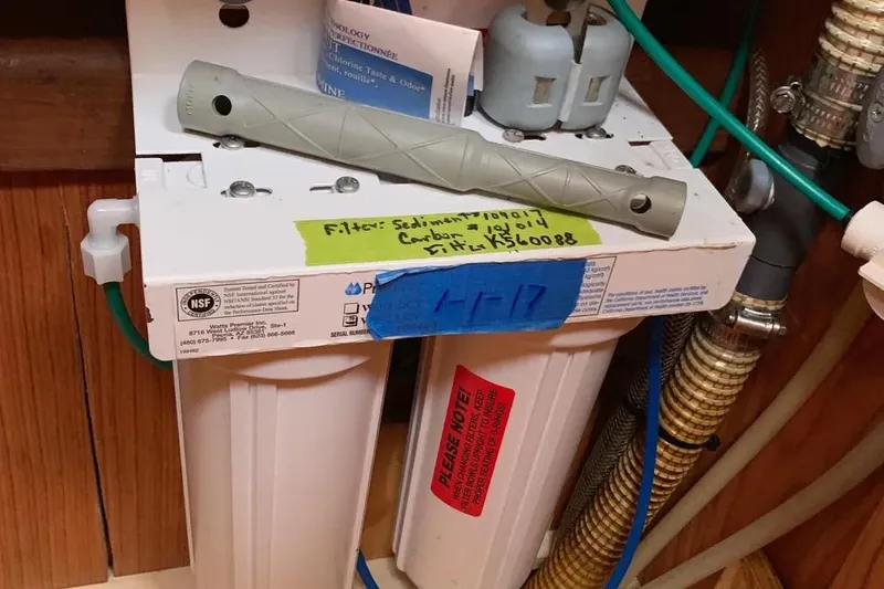 Slide: The Image of Water filtration system with labeled filters, Hunter 460 model, year 2000, installed in wooden cabinet. - 63