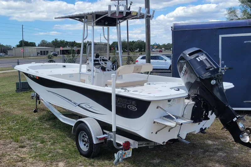 The Image of 2014 Carolina Skiff 218 DLV boat with Mercury 115 outboard motor on trailer. - 1